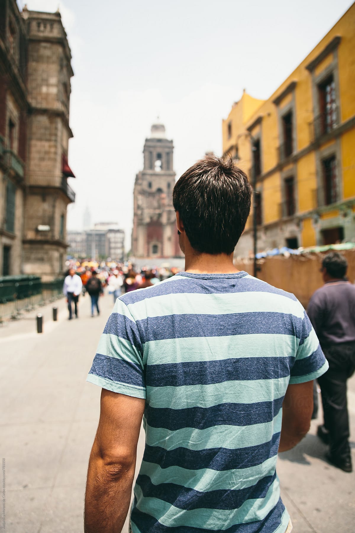 Young man walking down a traditional mexican street on a sunny day