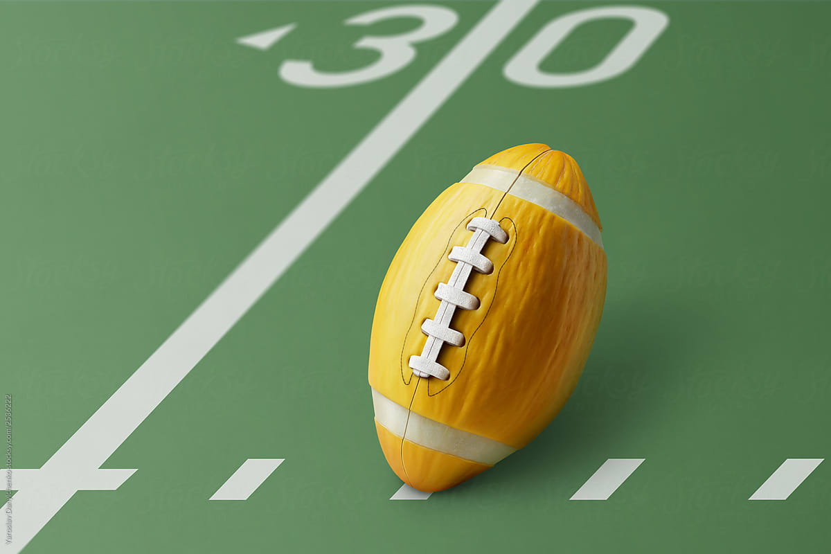 Yellow melon in the shape of an american football ball on a green field with space for text