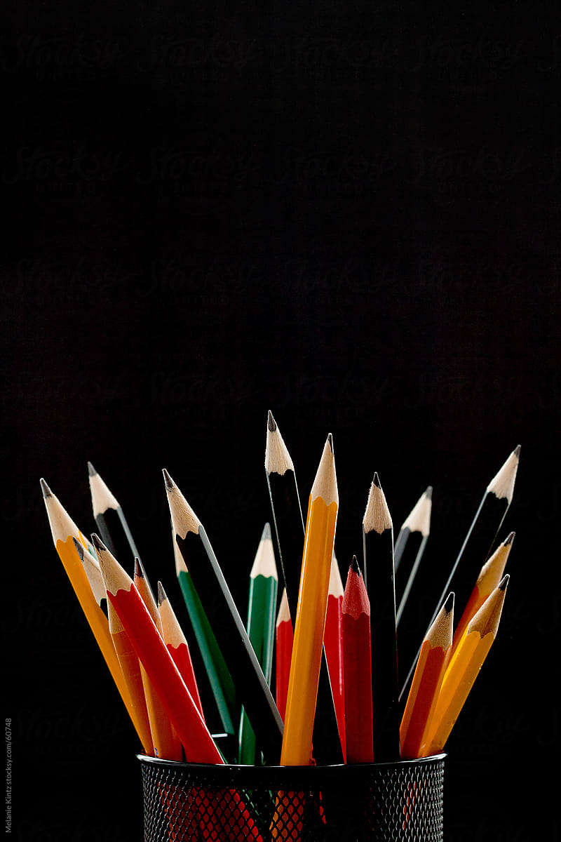 One Smaller Red Pencile Among A Group Of Other Black Pencils Before Black  Background by Stocksy Contributor Melanie Kintz - Stocksy