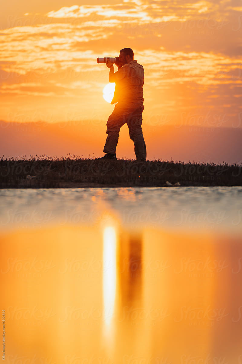 Silhouette of a photographer in sunrise