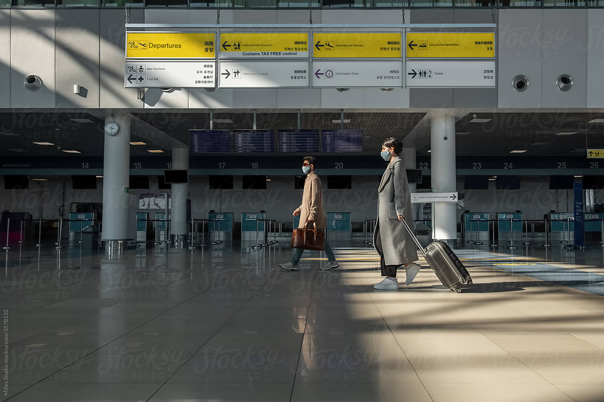 Male and female travelers walking in airport terminal