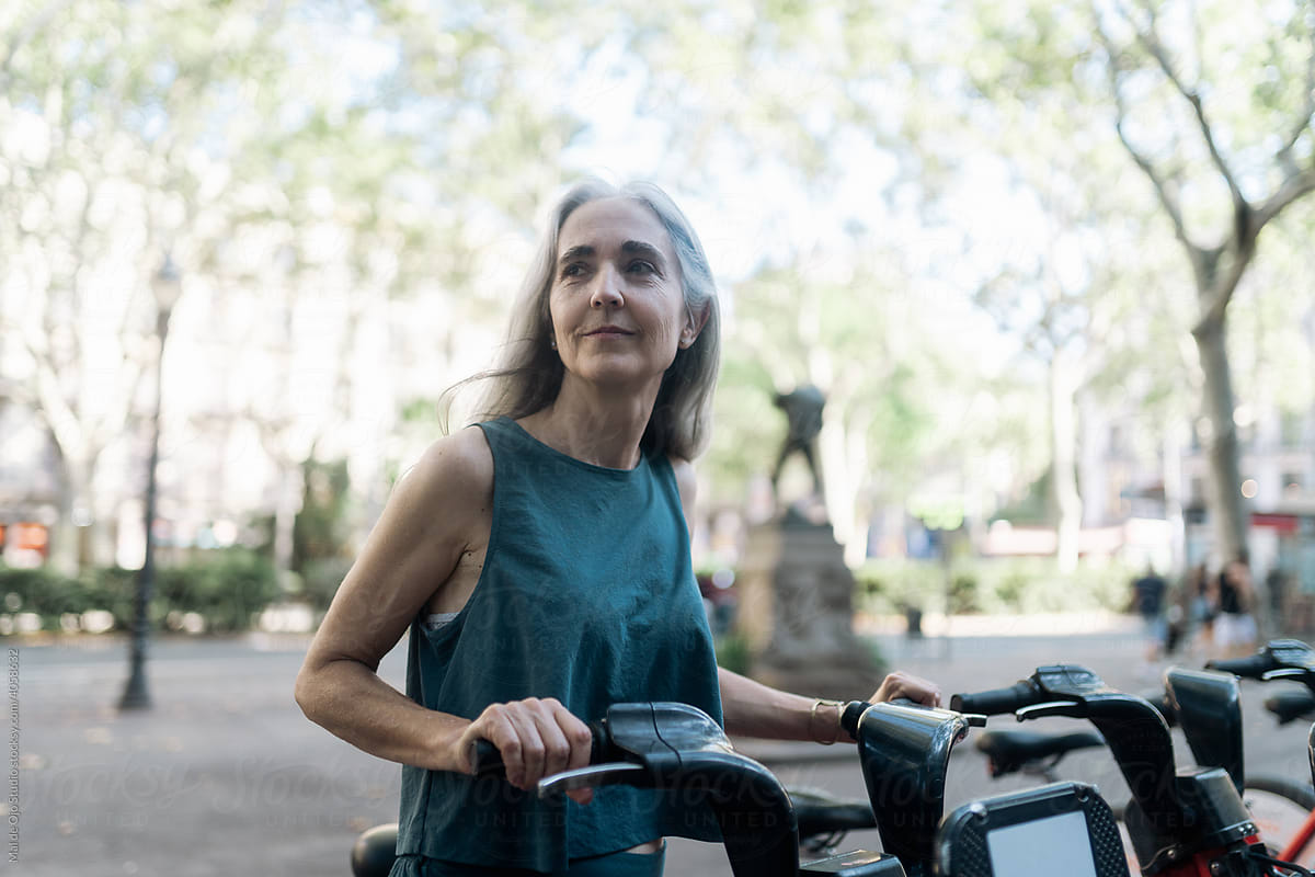 Grey-haired woman picking up a rental bike