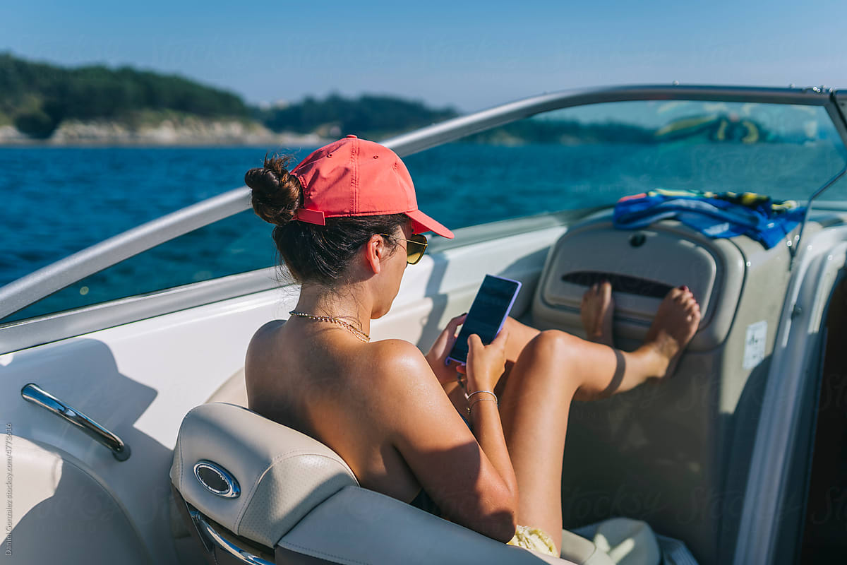 Woman texting message on smartphone in boat