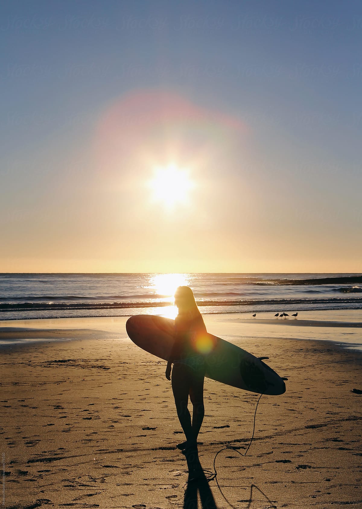 Girl In Bikini Walking Beach With Surfboard On Her Head Sun Flare Behind Del Colaborador De 