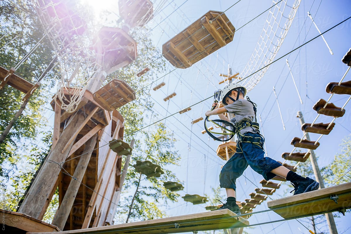 Young boy makes his way across a ropes course