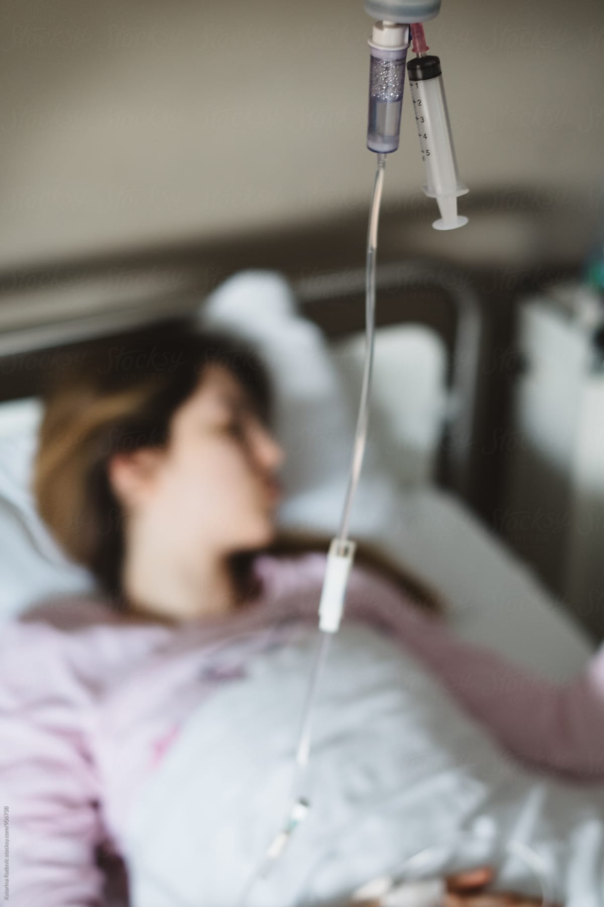 Woman lying in a Hospital Bed While Having Intravenous Therapy