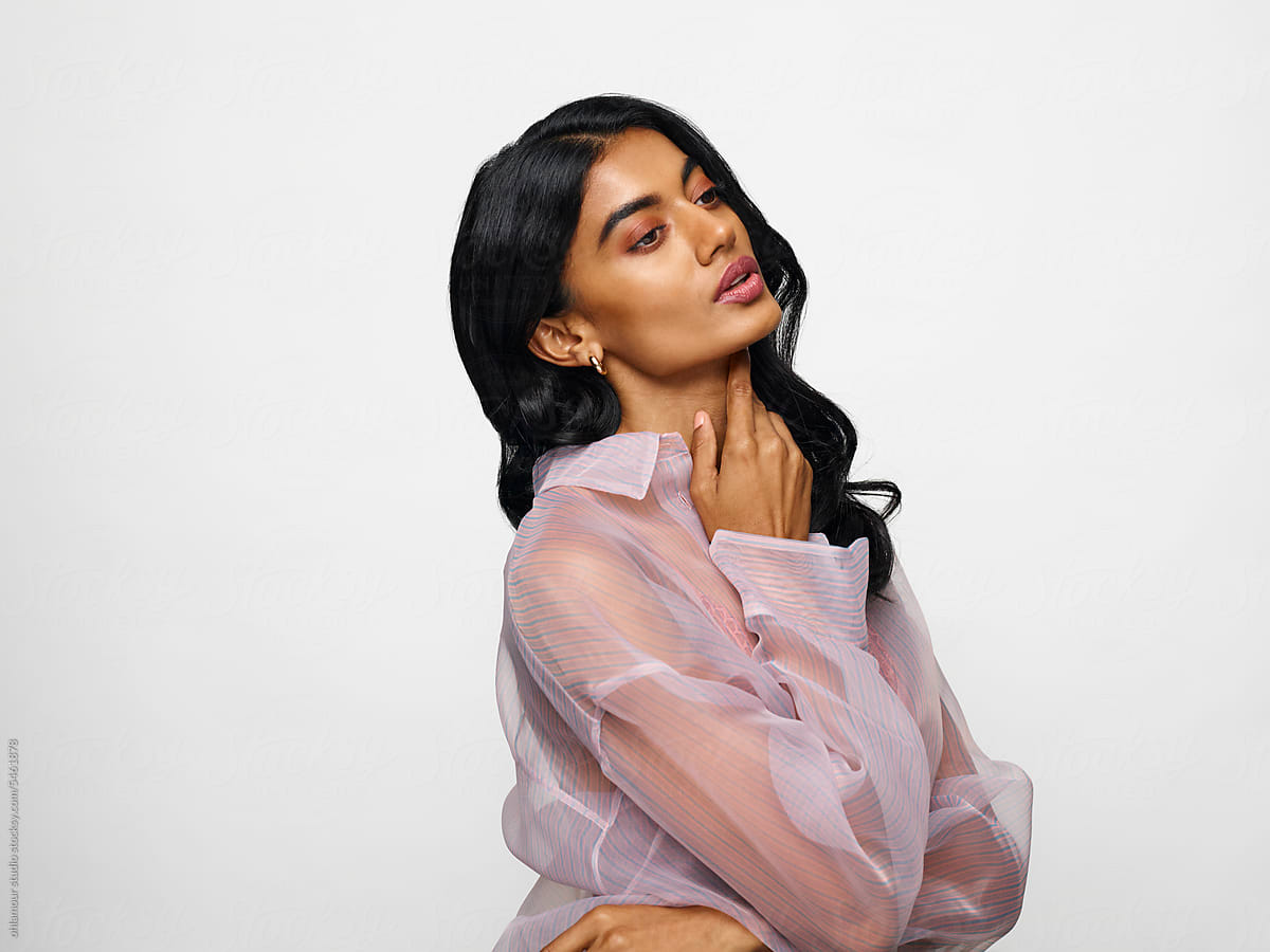 Woman wearing transparent blouse over white background