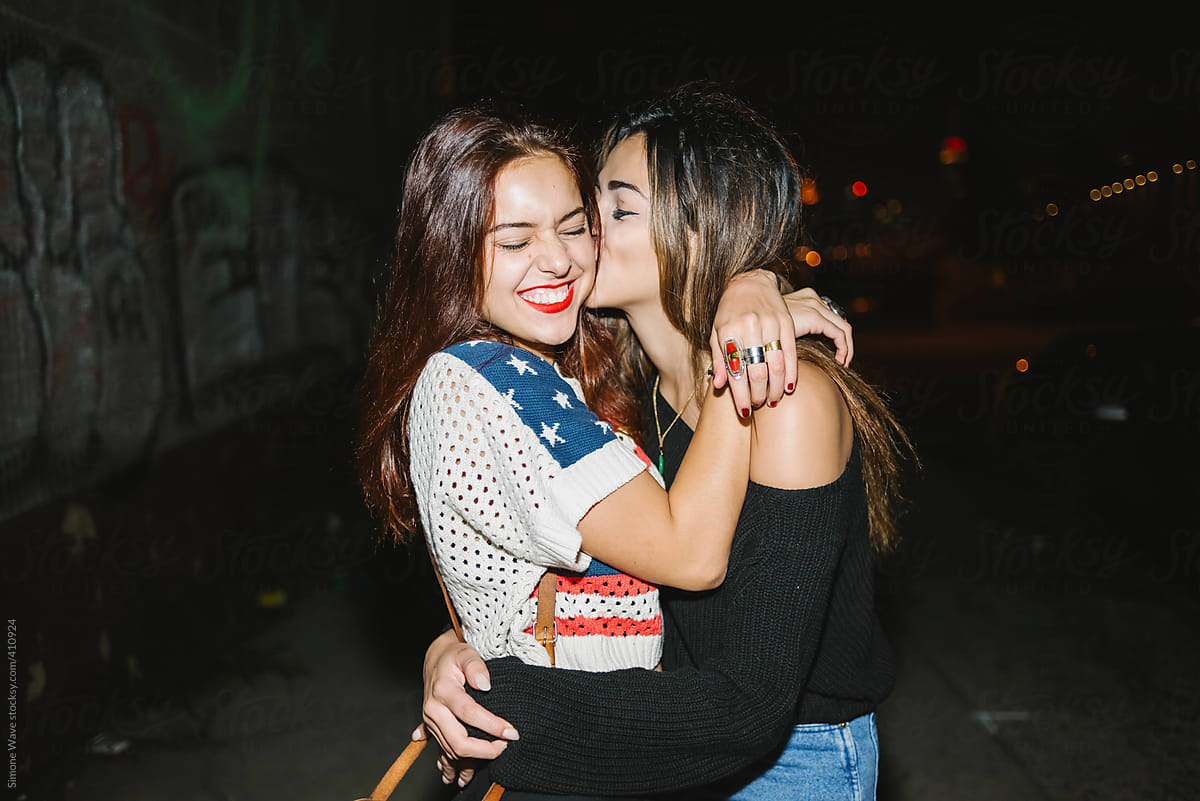 Affectionate Female Best Friends Hugging Outdoors In The Night By