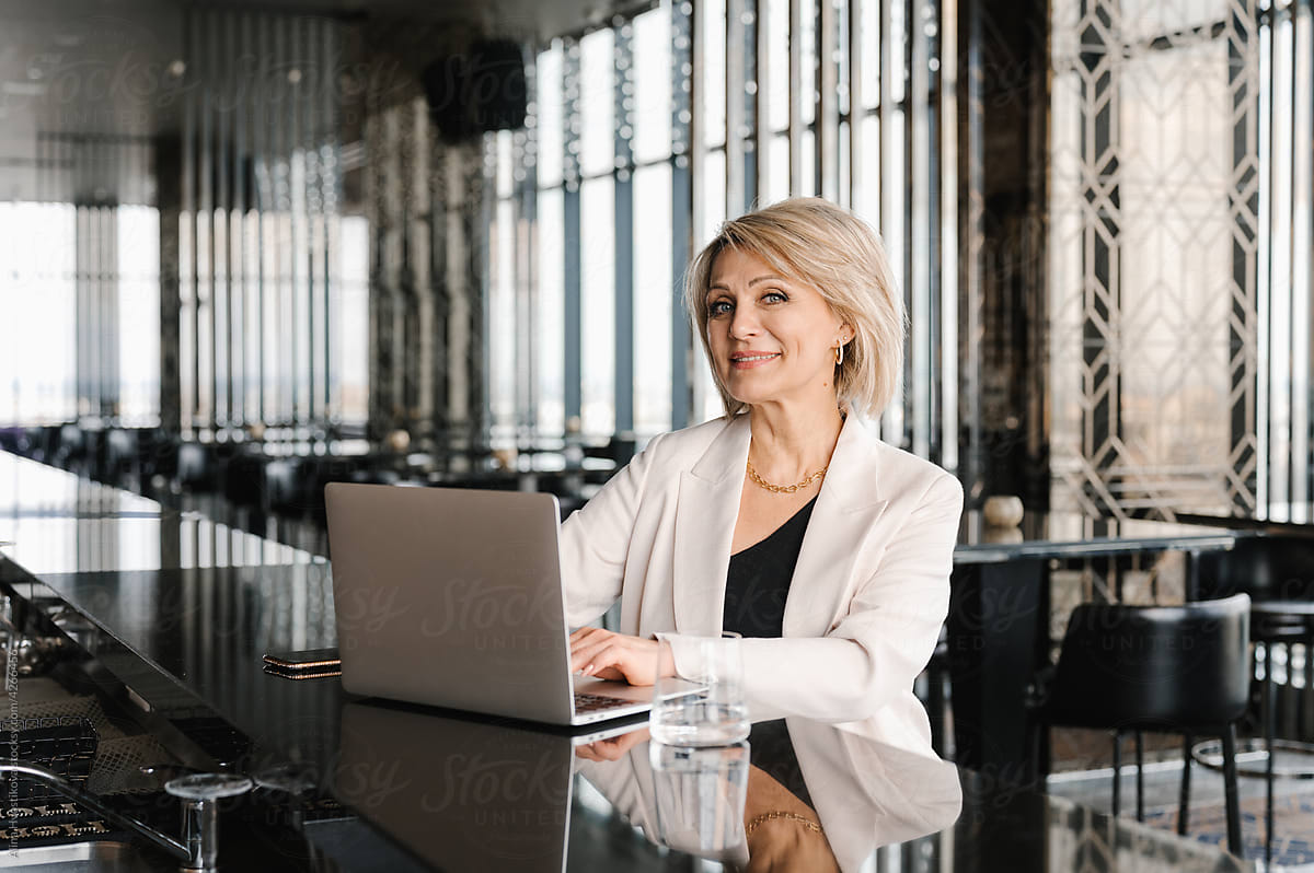 Businesswoman typing on laptop in restaurant