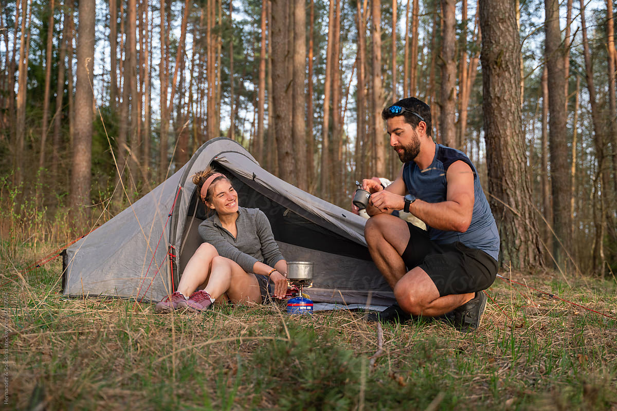 Couple Cooking Food While Camping In The Woods