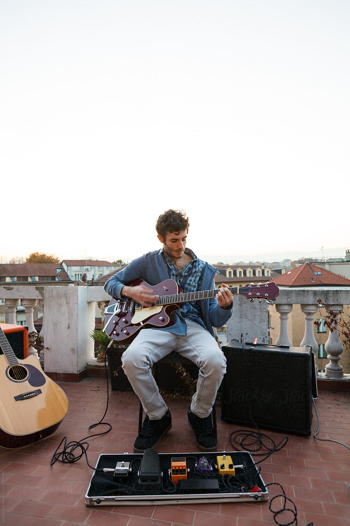 young man playing guitar on a terrrace