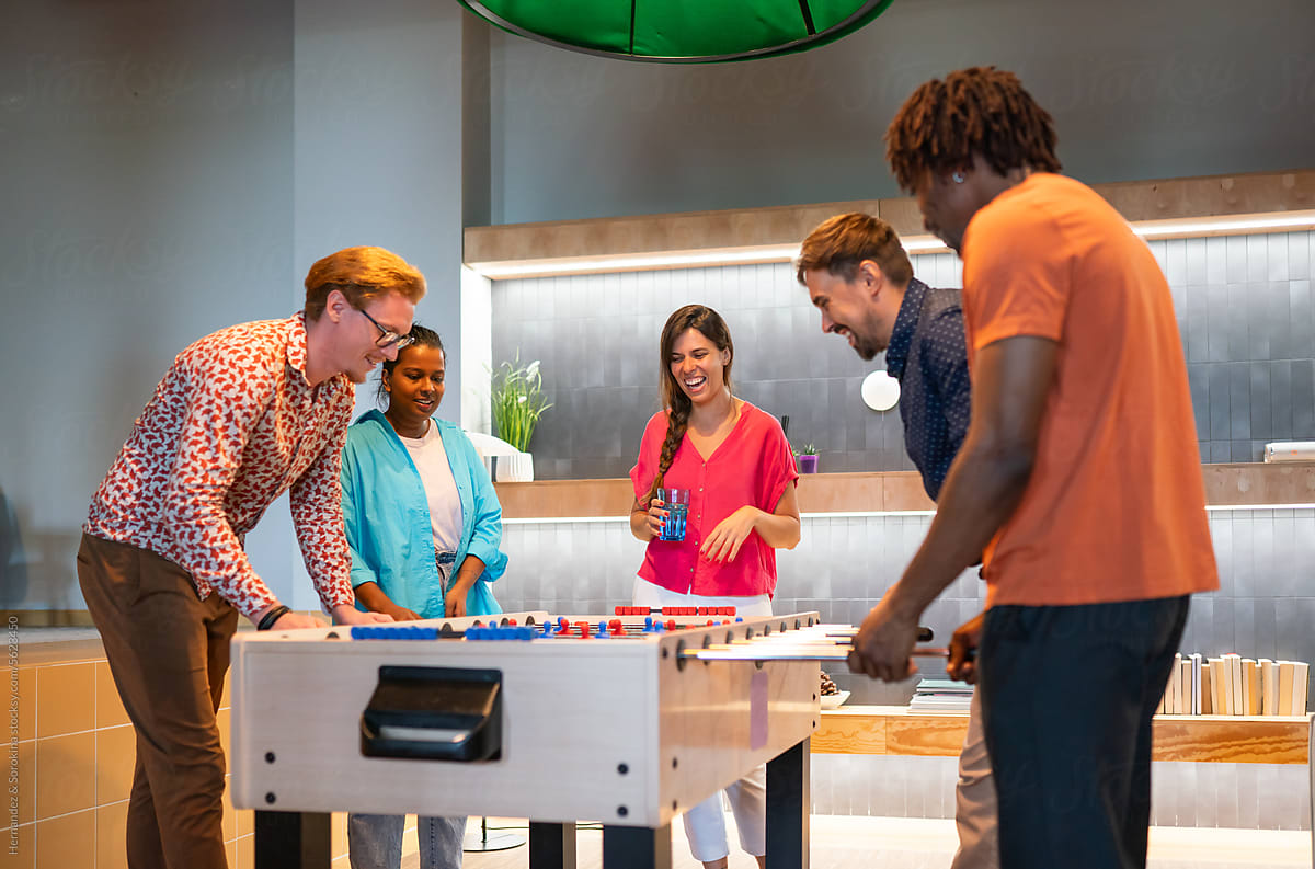 People Playing Table Soccer Game At Office