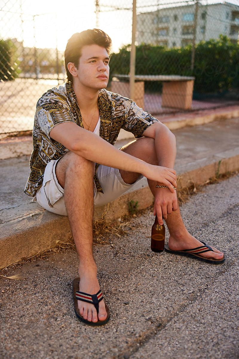 Young man resting on street at sunset