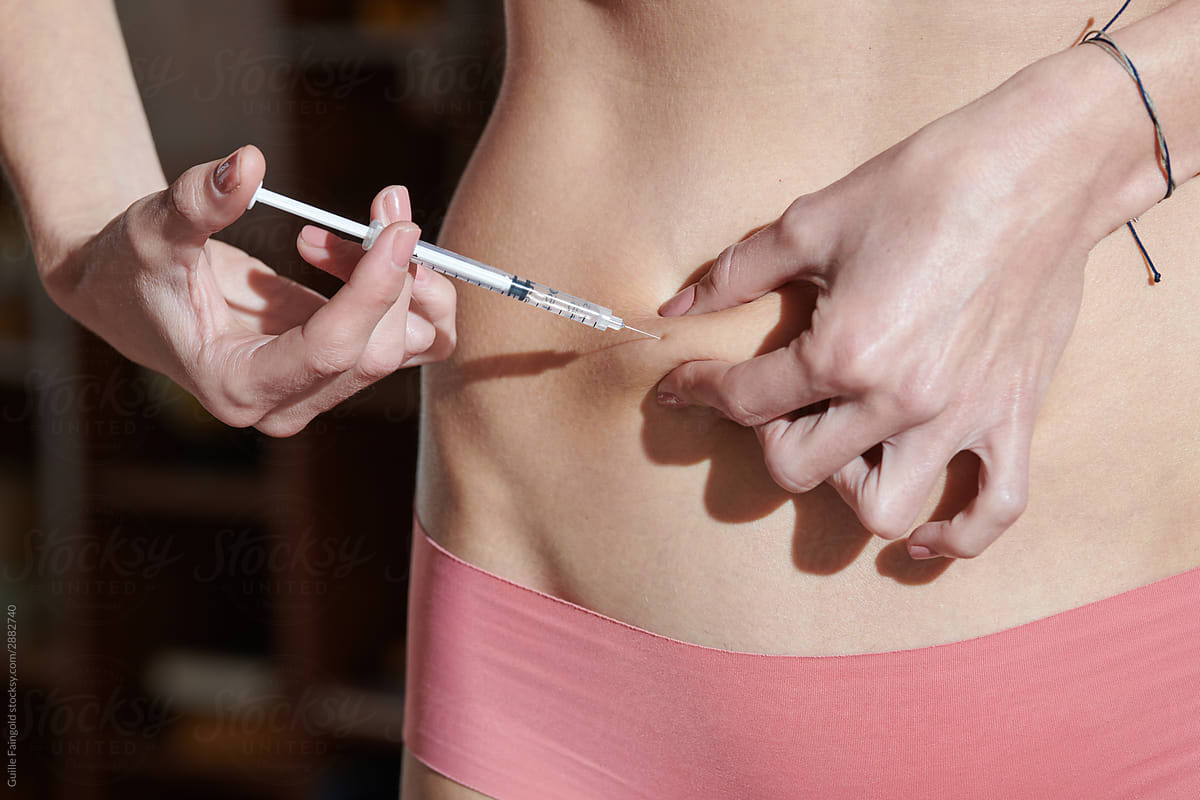 Girl making abdomen injection at home