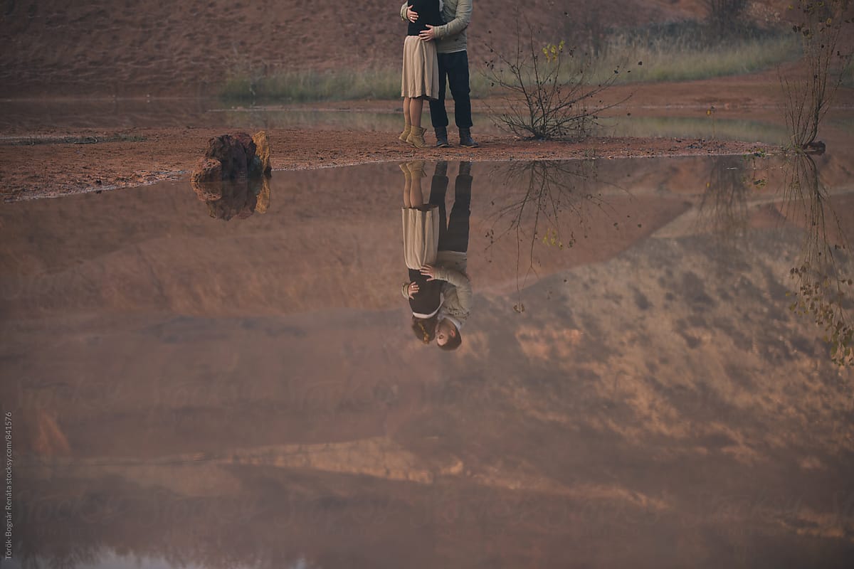 Reflection of a lovely couple at the mountains