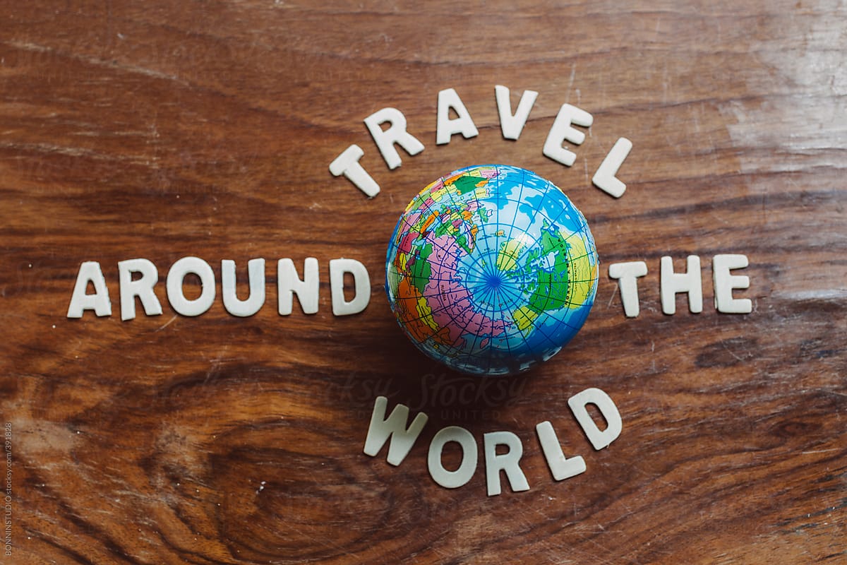 Travel around the world. Small globe on wooden background.