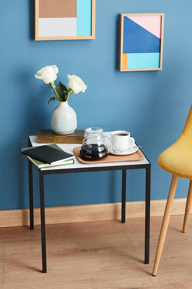 Modern table with coffee, flowers and books.