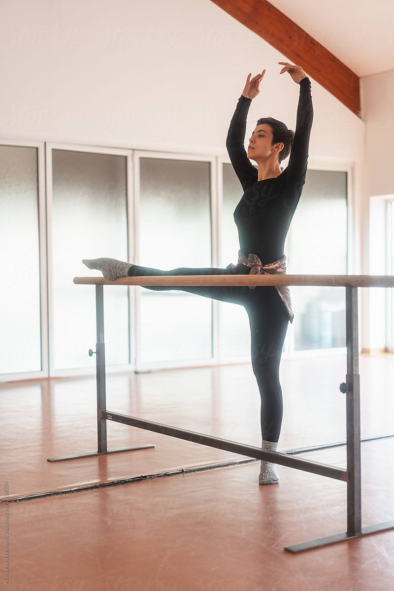 Dancer Stretching Her Leg On The Ballet Bar