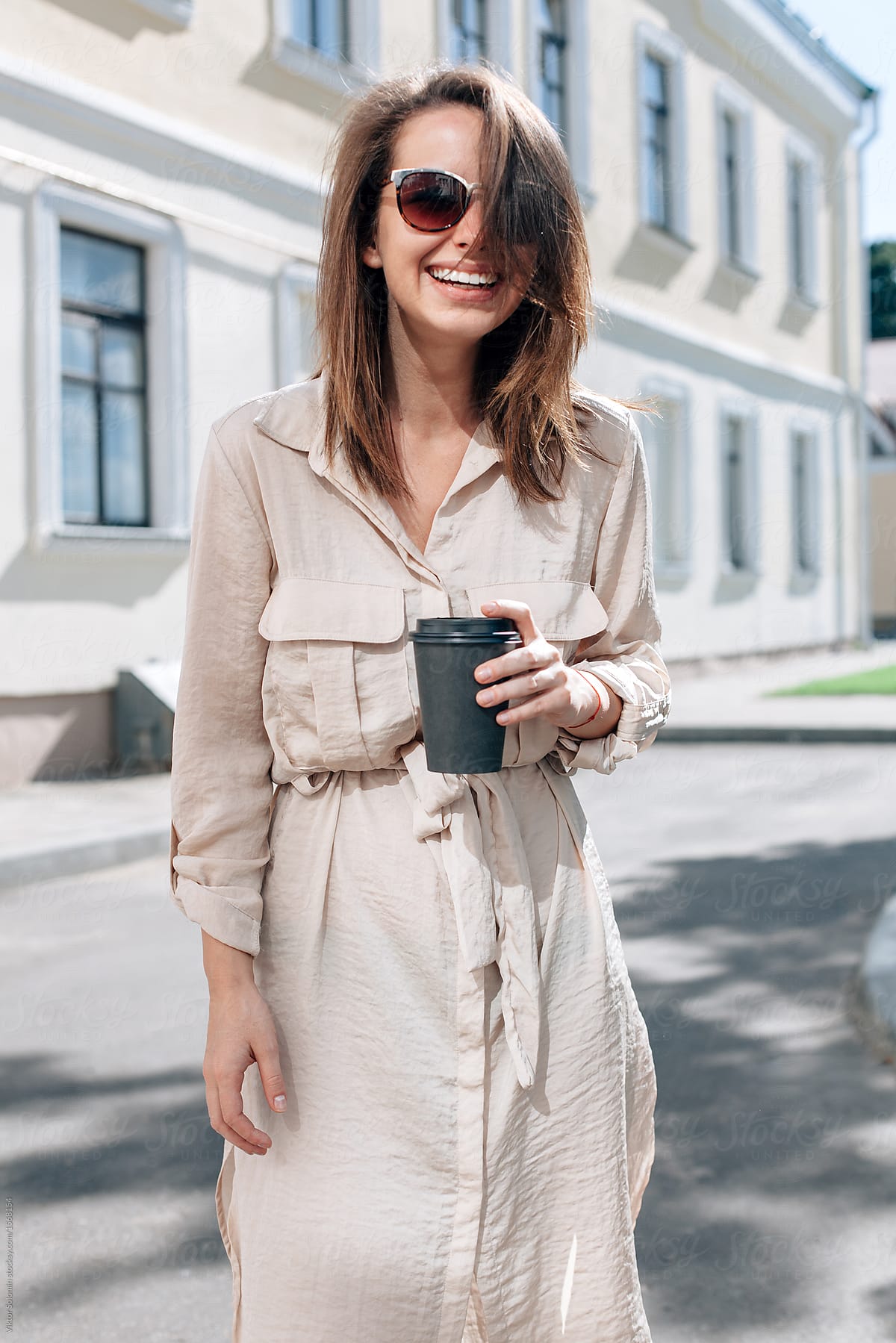 laughing woman cup coffee hands standing street