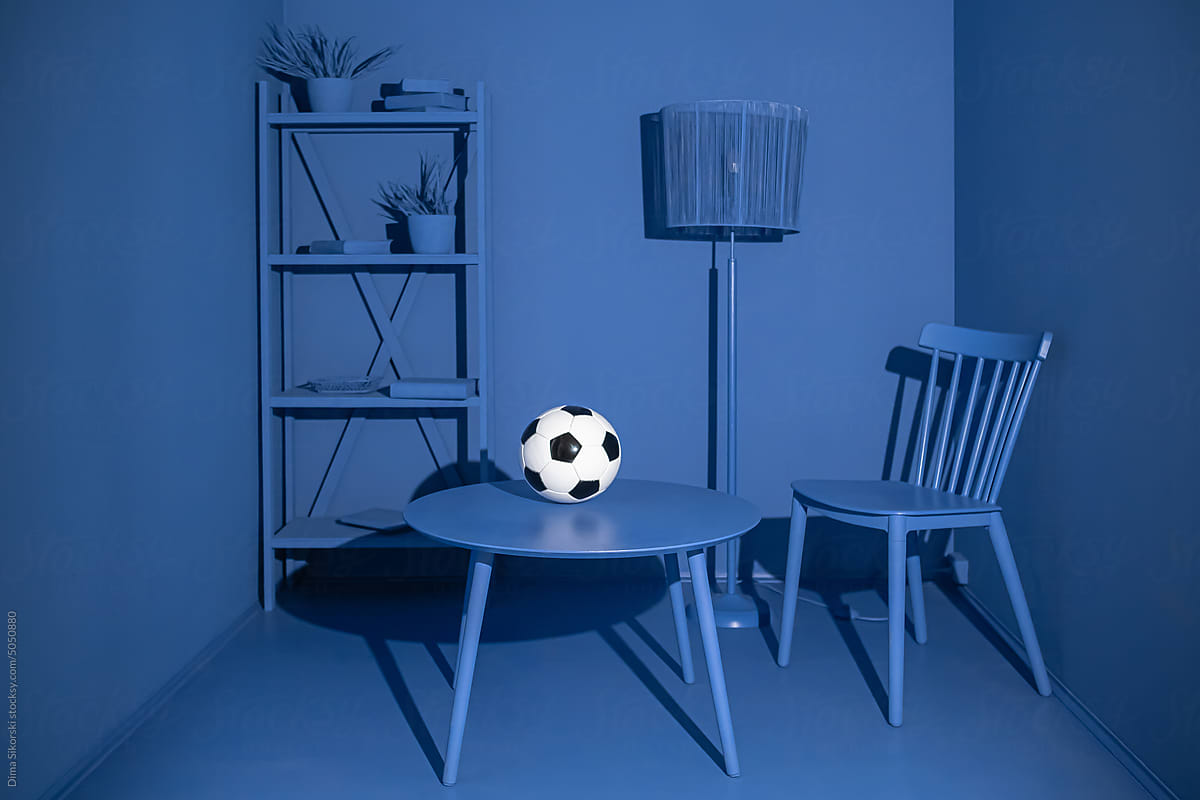 A soccer ball in the bleached blue interior of a living room