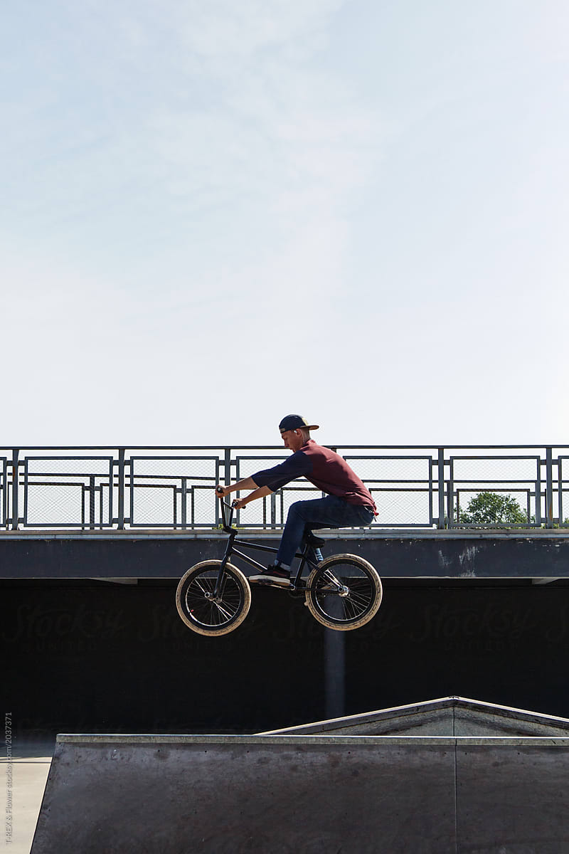 Young guy jumping on bike