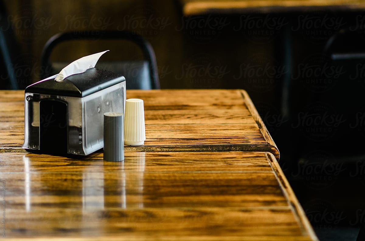 napking dispenser and salt and pepper shakers on a table