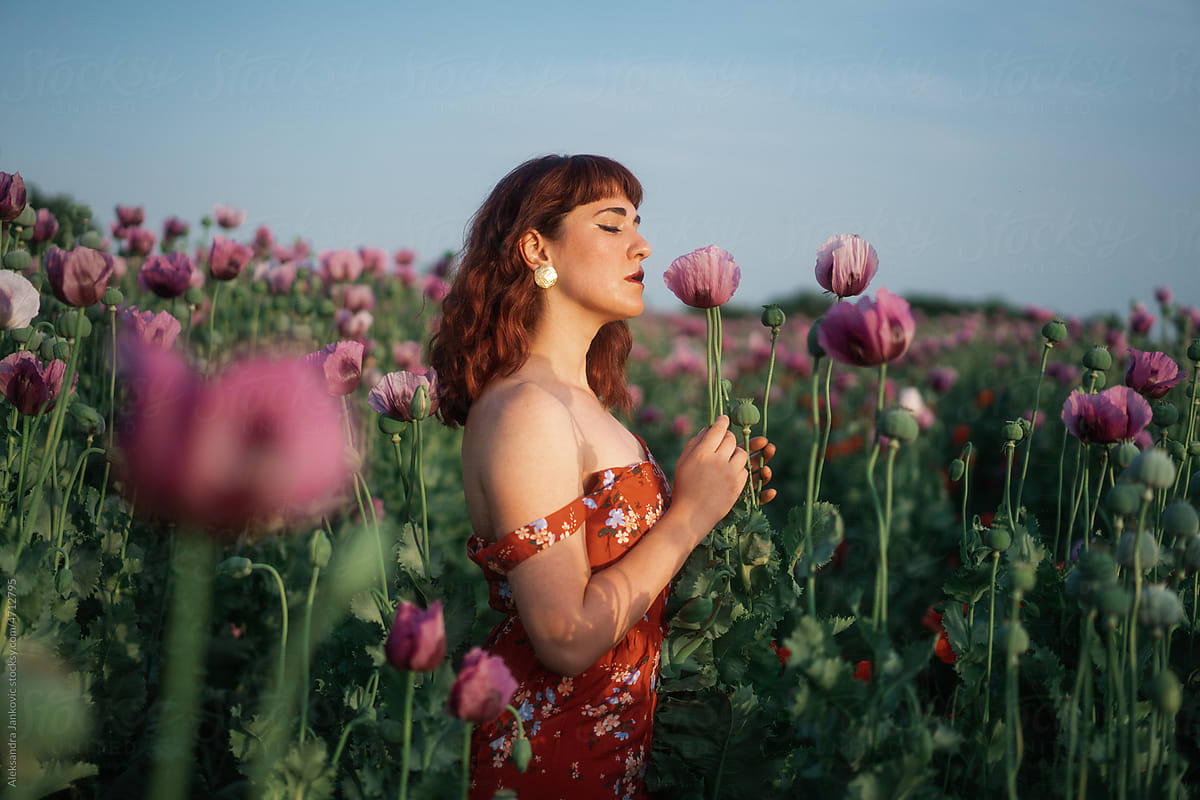 Dreamy Portrait Of A Redhead Woman In The Field Smelling Flowers