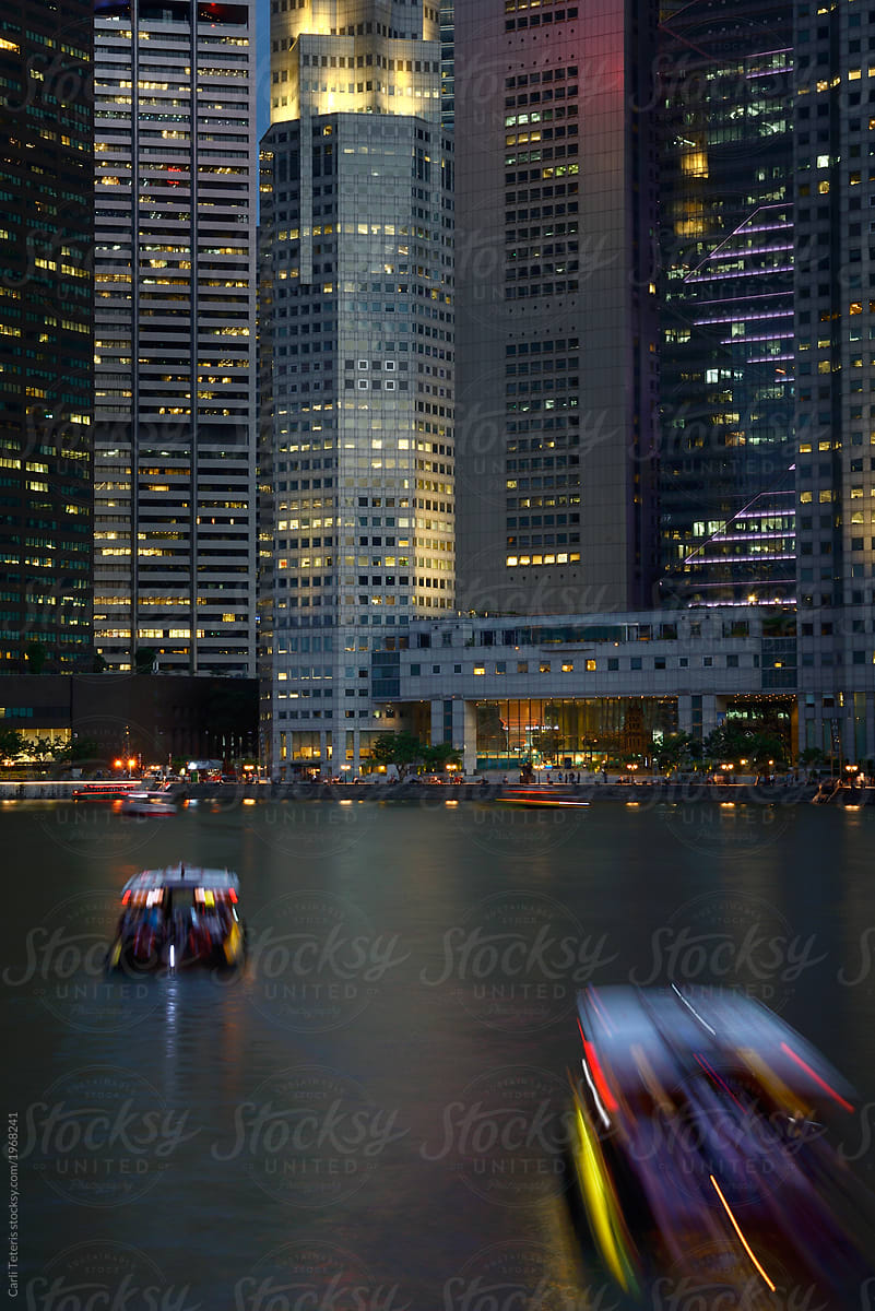 Water taxis at Boat Quay traveling towards Singapore\'s Central Business District