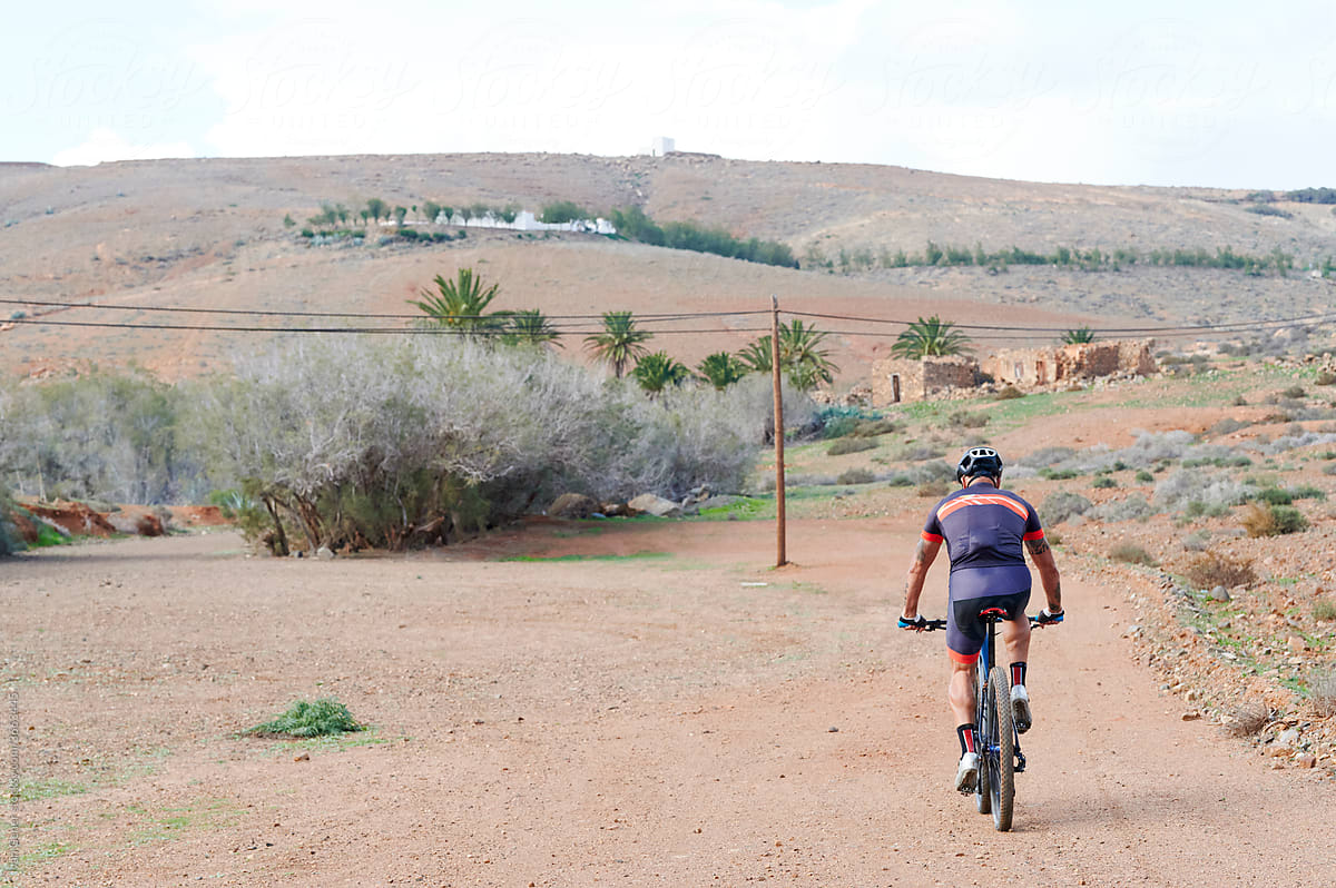 Man mountain biking in arid countryside