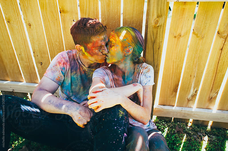 Couple Against Fence Covered in Holi/Colored Powder
