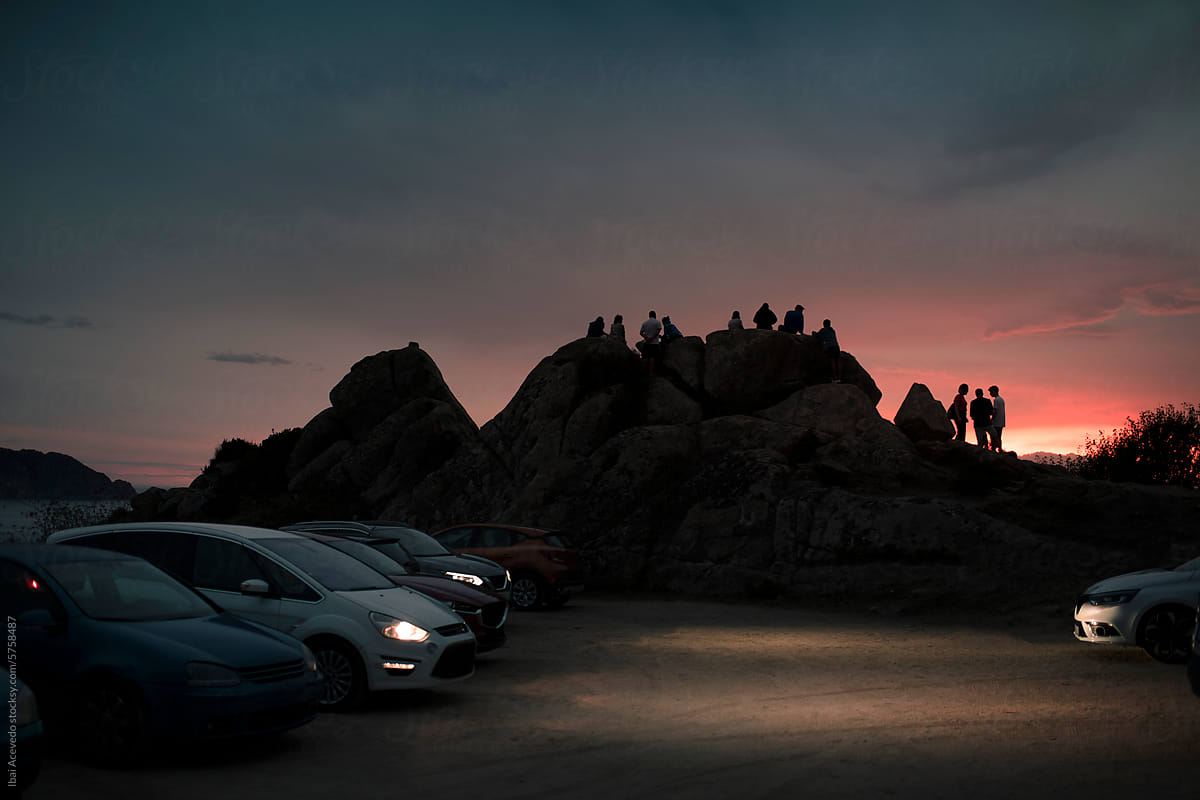 Striking sunset people silhouettes at car parking