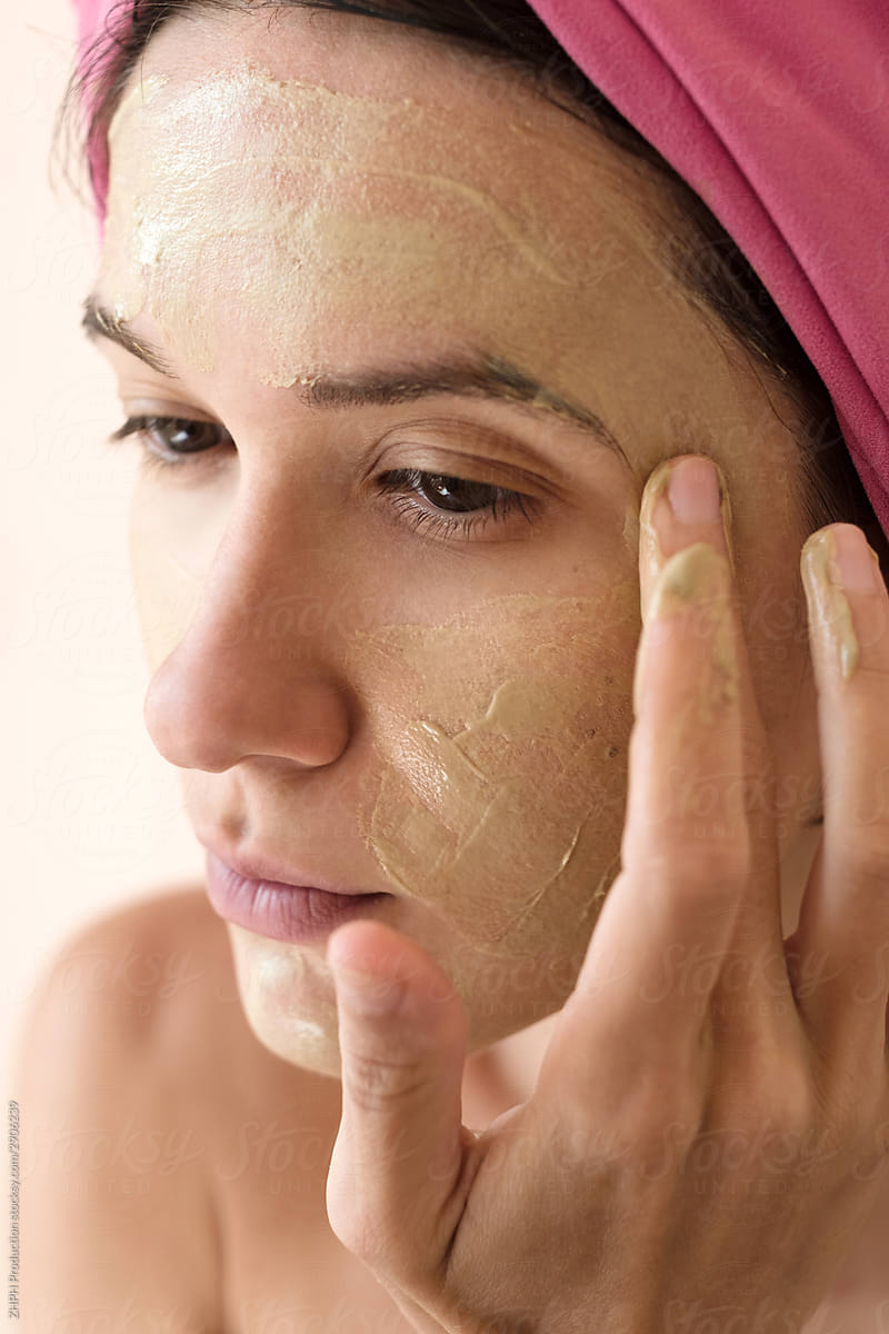 Woman applying clay beauty mask
