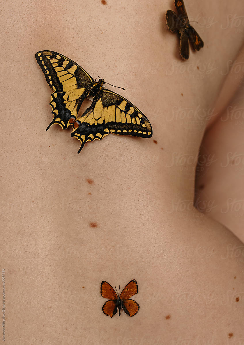 Close up photo of the woman\'s skin texture with moles and butterfly