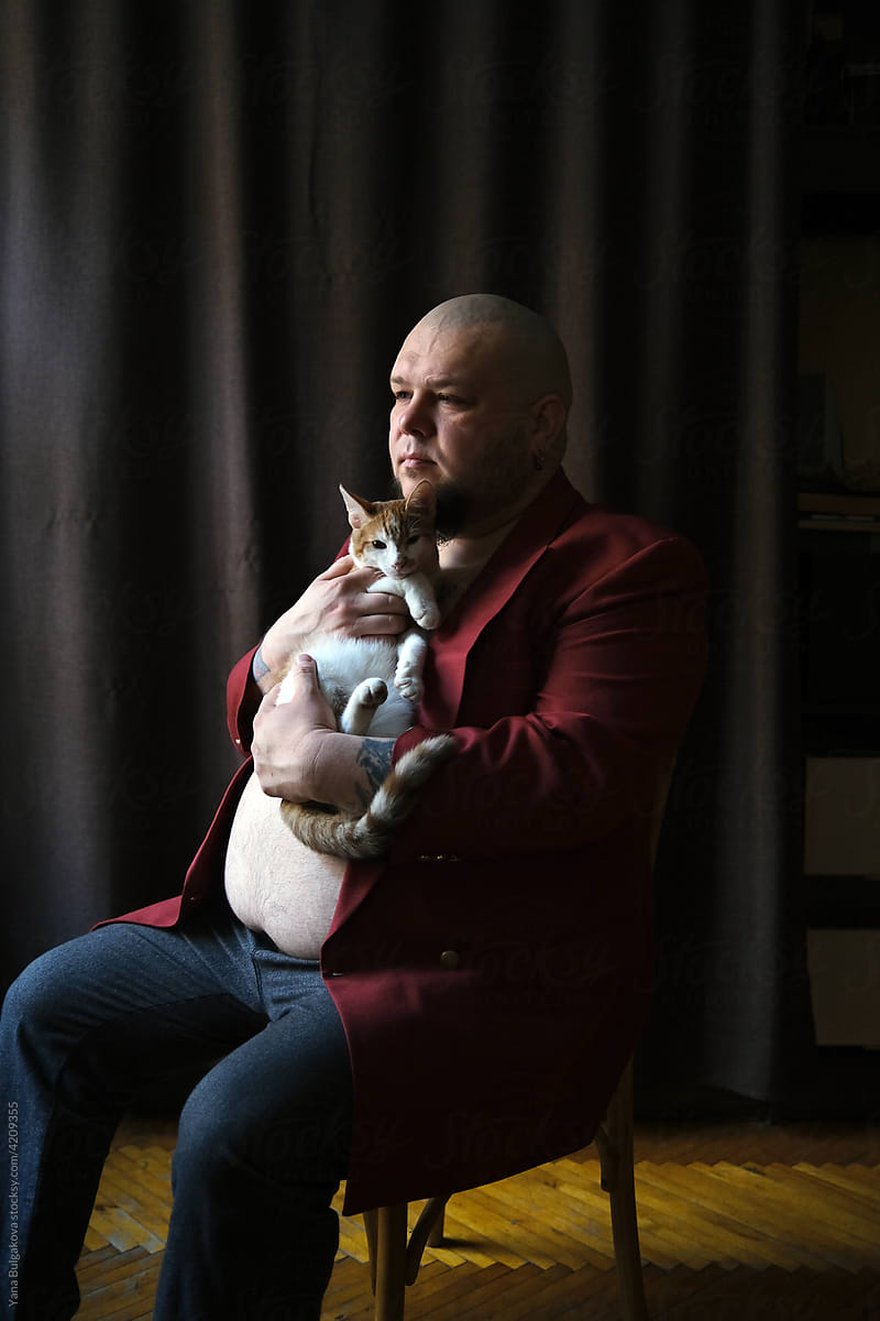 Man sitting with the cat on a chair