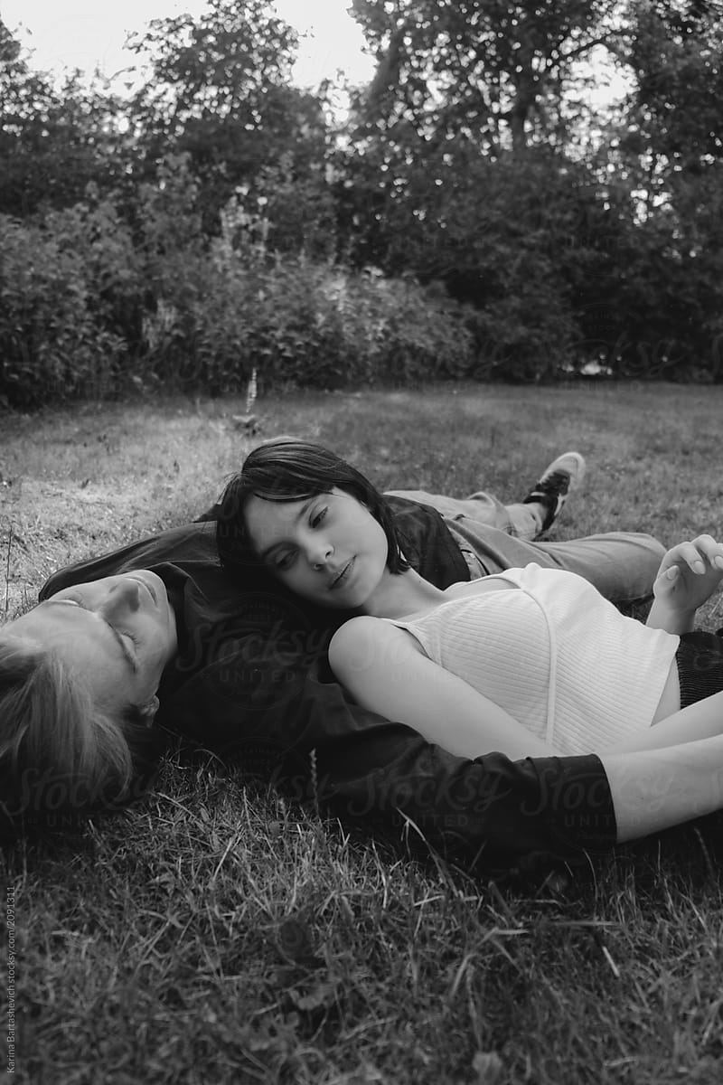 young beautiful couple lying on the grass in an embrace