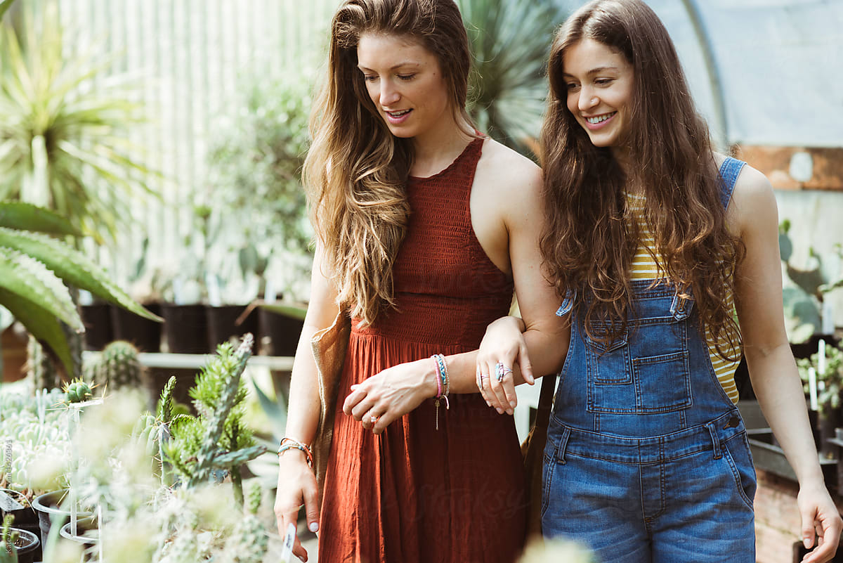 Two young women exploring a greenhouse together.