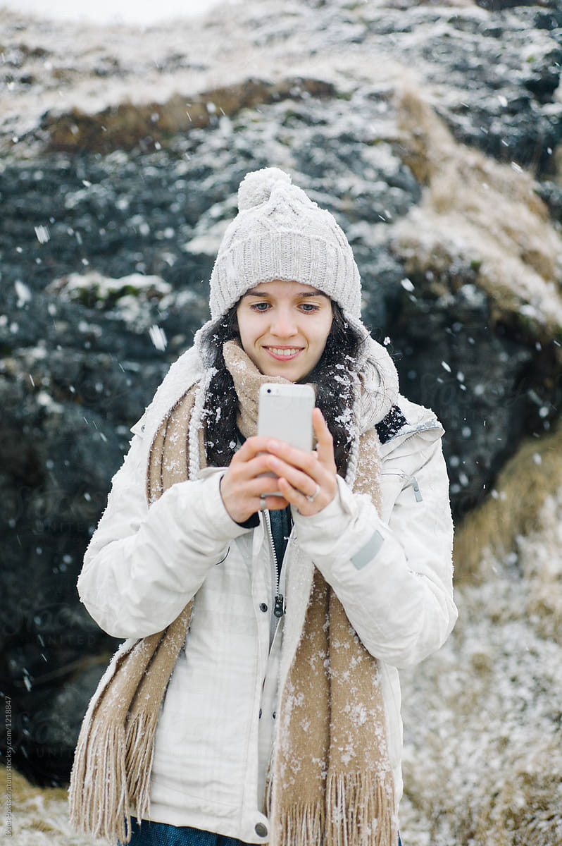 Smiling female with smartphone on Icelandic background