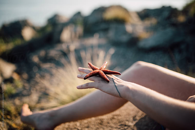 Close up of a sea star on the hand of a young woman