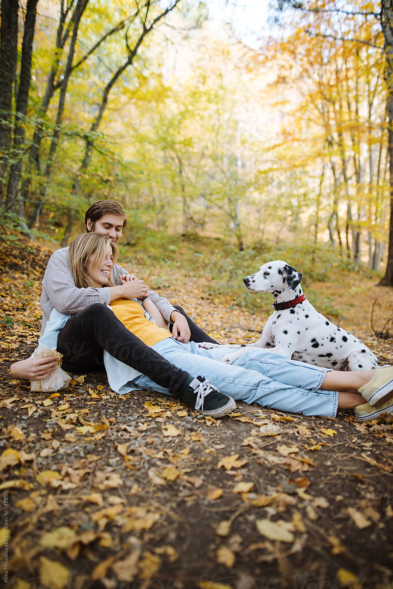 Young couple with dog in autumn forest