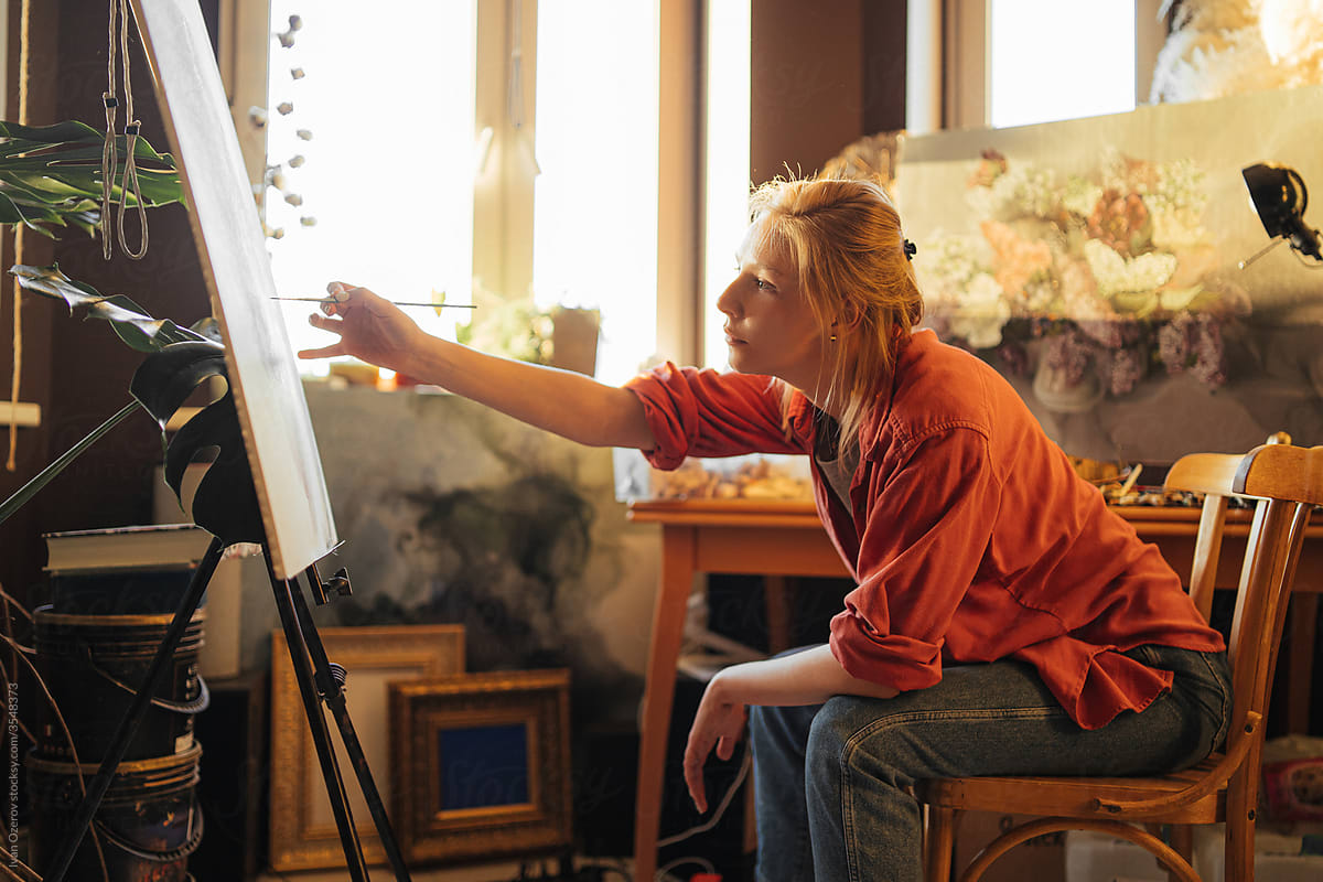 Female artist painting in cozy workshop