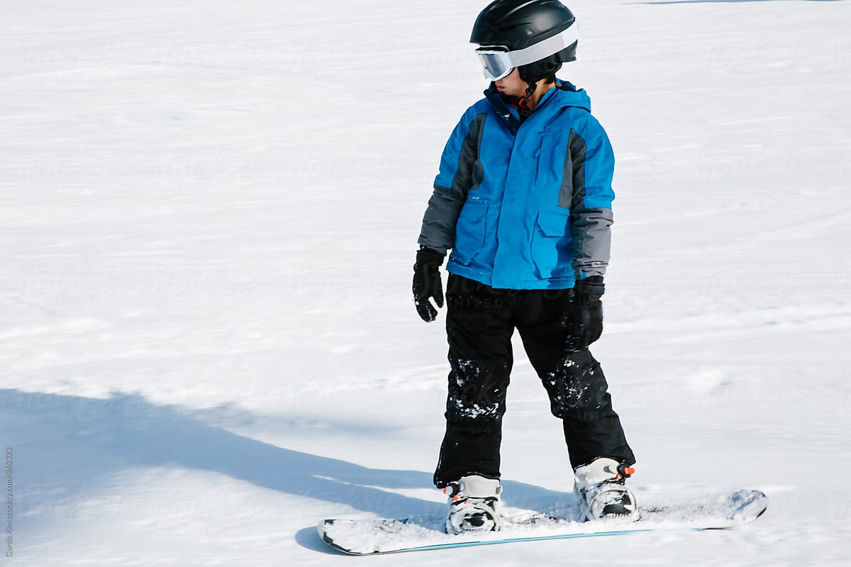 Cool kid snowboarding on white powder