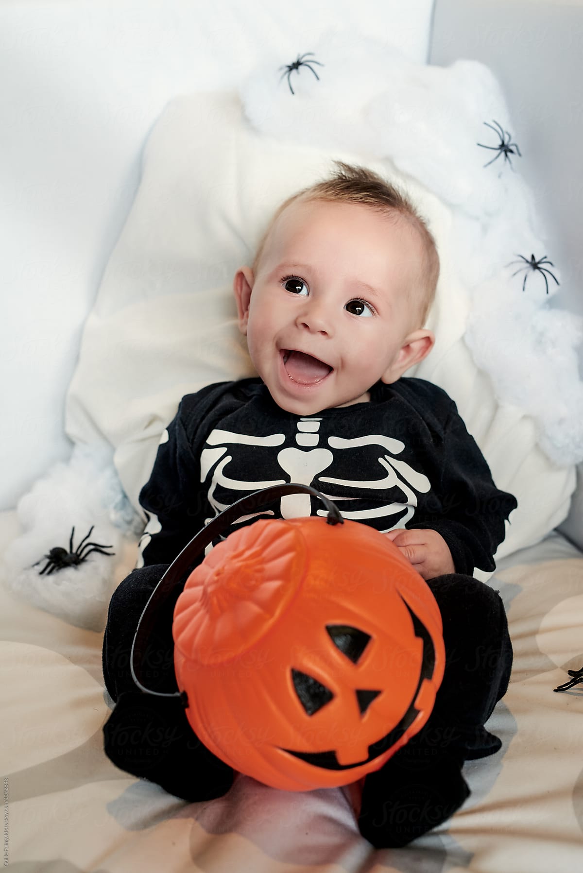 Excited baby with trick or treat bucket