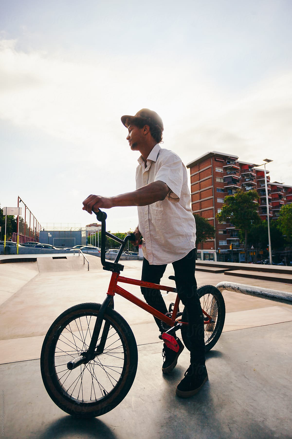 Young man standing with his BMX bike in a skate park.