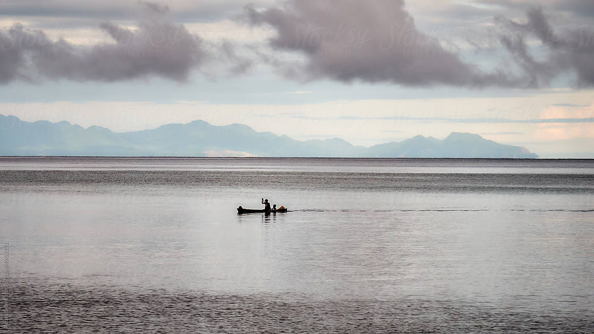 Woman, child paddling a dugout canoe silhouette, Savo, Pacific Islands