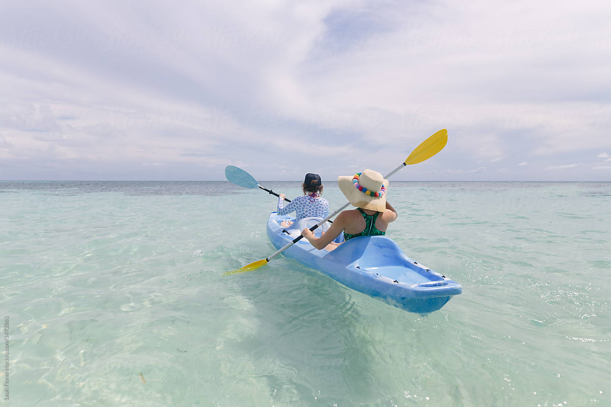 Women Paddling into Ocean on Kayak
