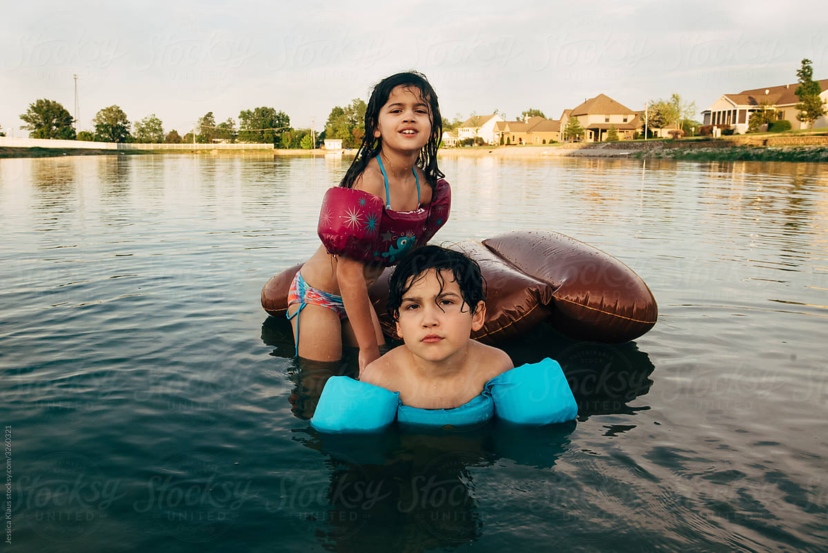 Boy and girl swimming in pond.