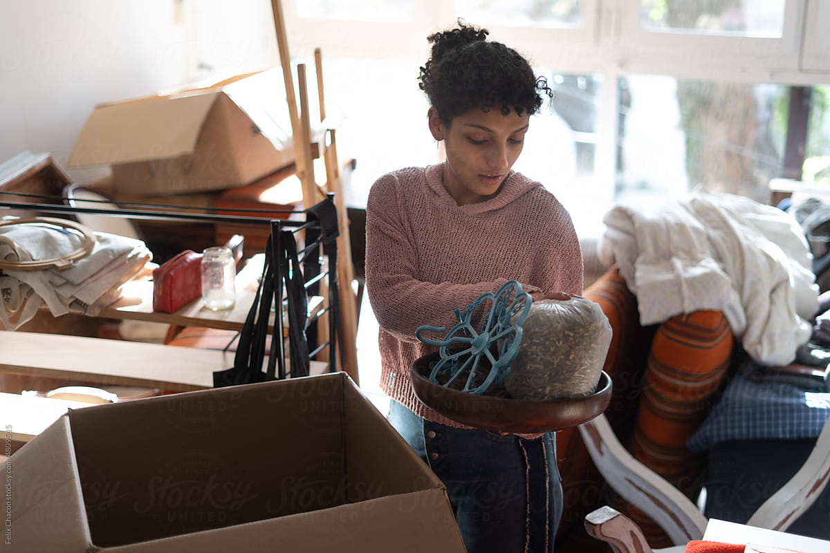 Woman Taking Things Out Of Box At Home