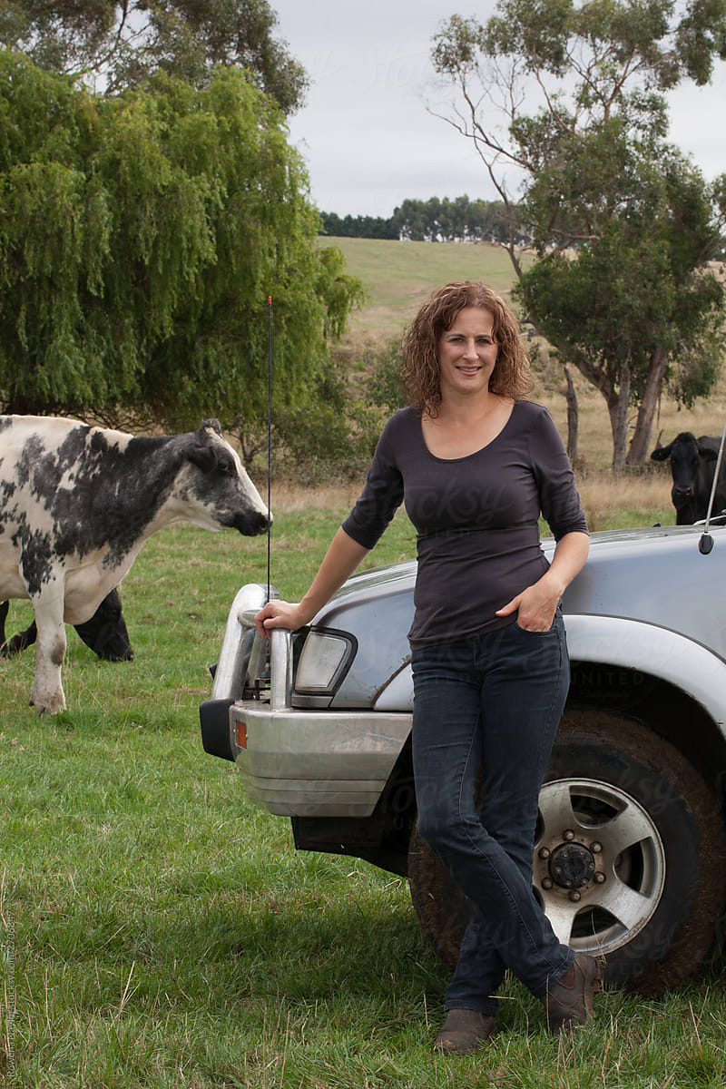 Female Dairy farmer standing in paddock against farm truck