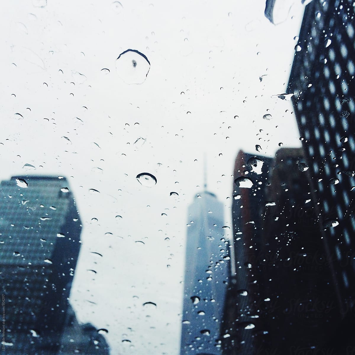 A view of the World Trade Building through a sun roof on a rainy day.