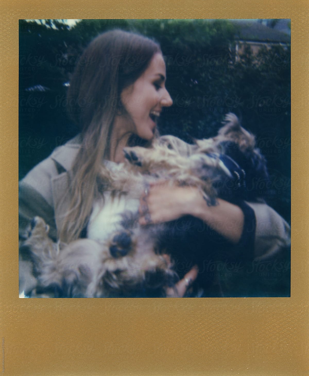 Polaroid scan of young woman holding a small dog with gold frame